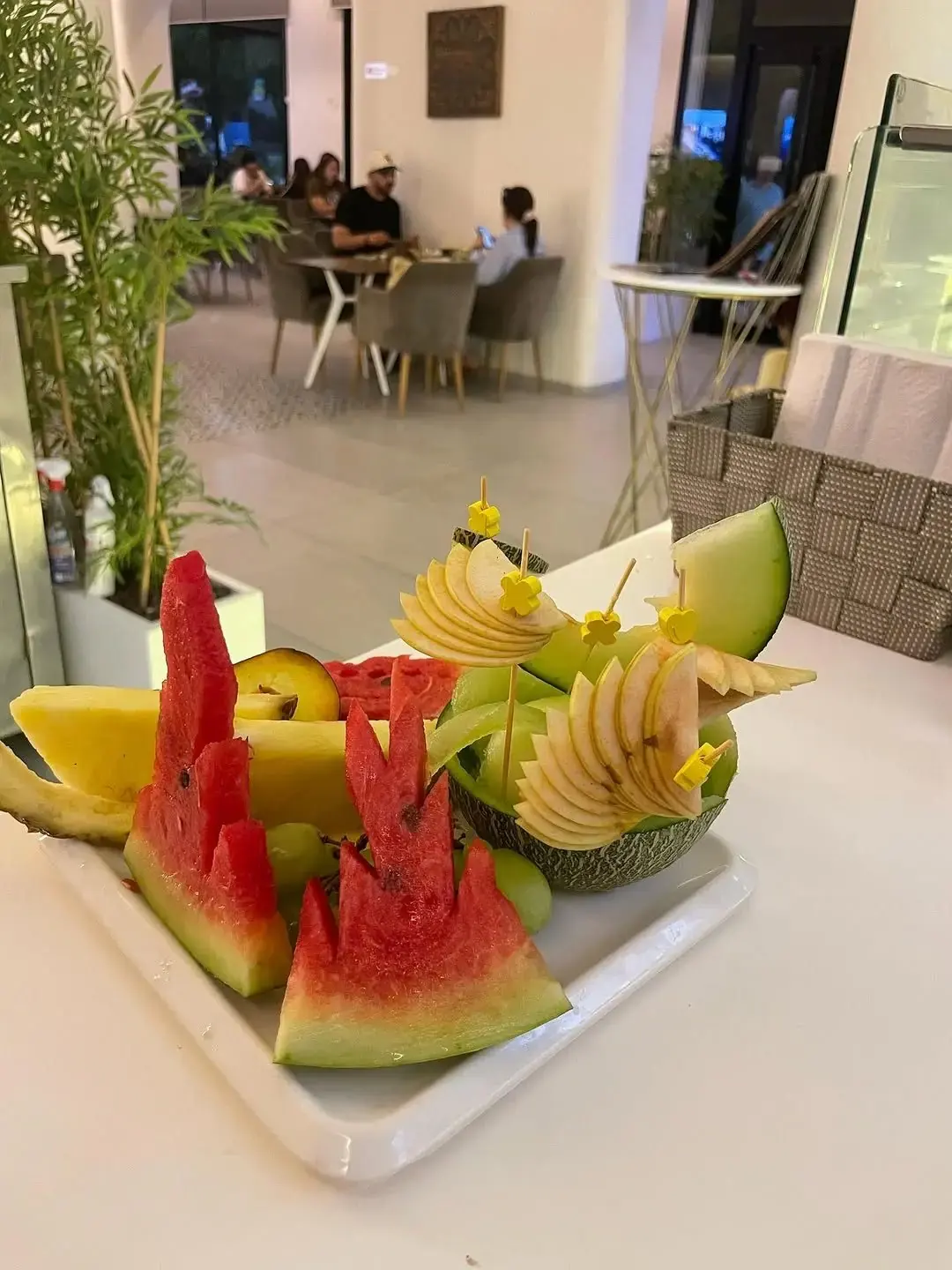 Plateau de fruits frais taillés : pastèque, melon, pomme et citron.