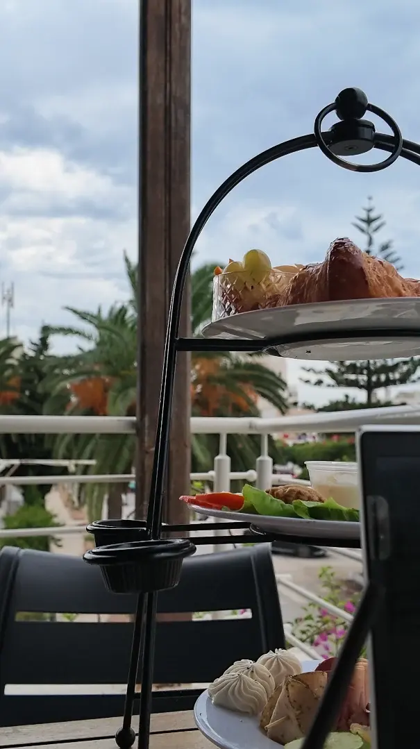 Silhouette d'un présentoir de brunch en fer forgé devant le ciel et les palmiers.